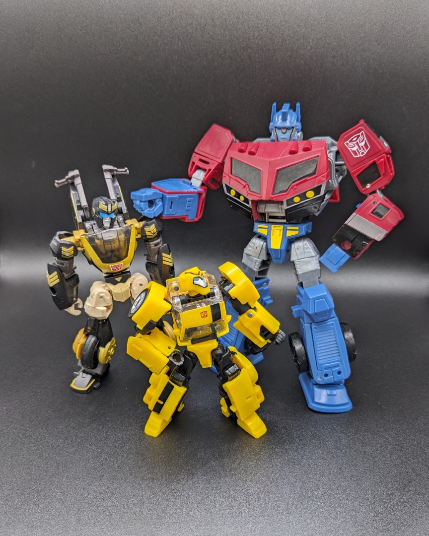 A picture of Legacy: United Animated Universe Optimus Prime alongside Prowl and Bumblebee.