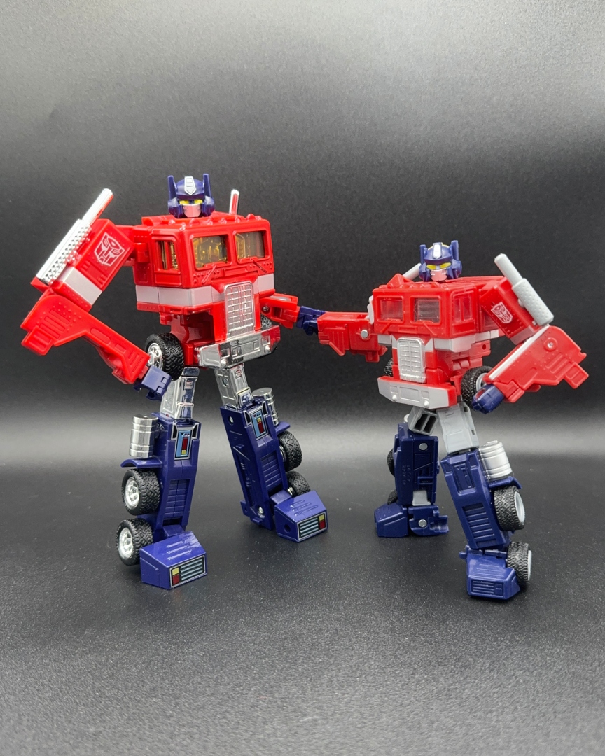 A picture of Legacy: United G1 Universe Optimus Prime standing side-by-side with Missing Link Convoy.