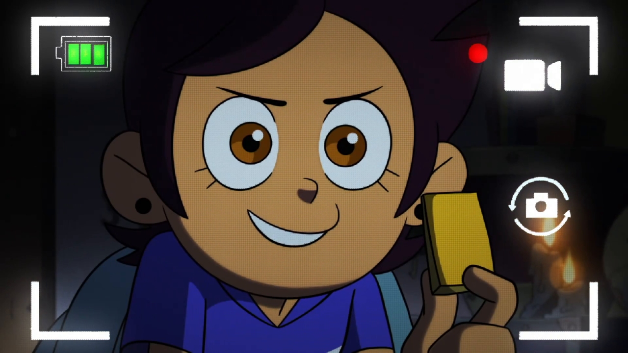 A screenshot from Young Blood, Old Souls, with Luz holding up a piece of Belos's mask during her message to her mother.